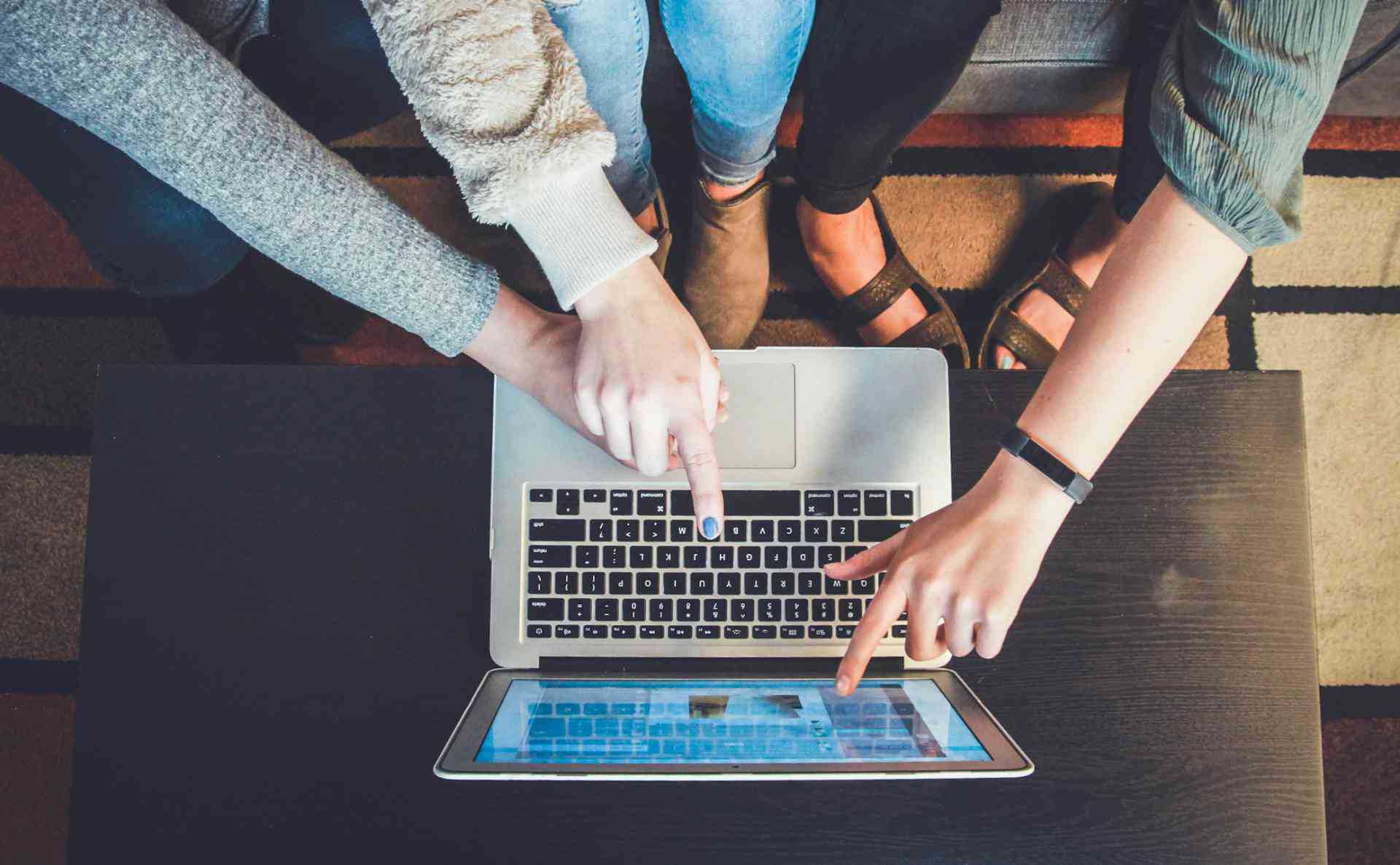 3 people pointing at a computer screen