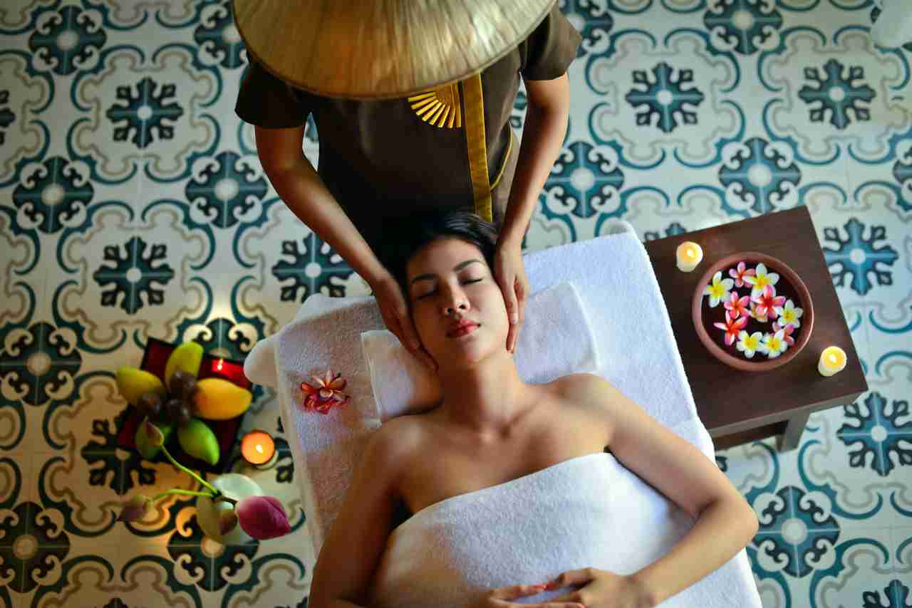 woman getting a South East Asian style massage with flowers and candles